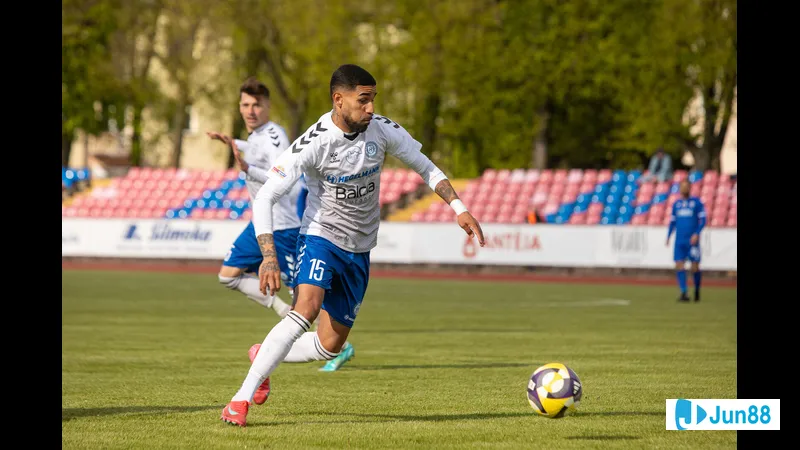 Cầu thủ của Dziugas Telsiai và Hegelmann tranh chấp bóng trên sân cỏ